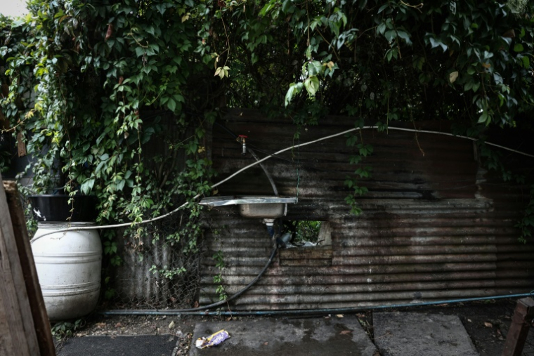 Une canalisation d'eau potable installée dans l'une des nombreuses ruelles du bidonville, le 26 septembre 2025, à Stains, en banlieue parisienne ( AFP / Thibaud MORITZ )