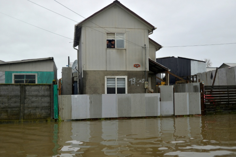 Des habitants dans leur maison dans une zone inondée à Arauco, dans la région de Biobio, le 16 juillet 2026 au Chili ( AFP / GUILLERMO SALGADO )