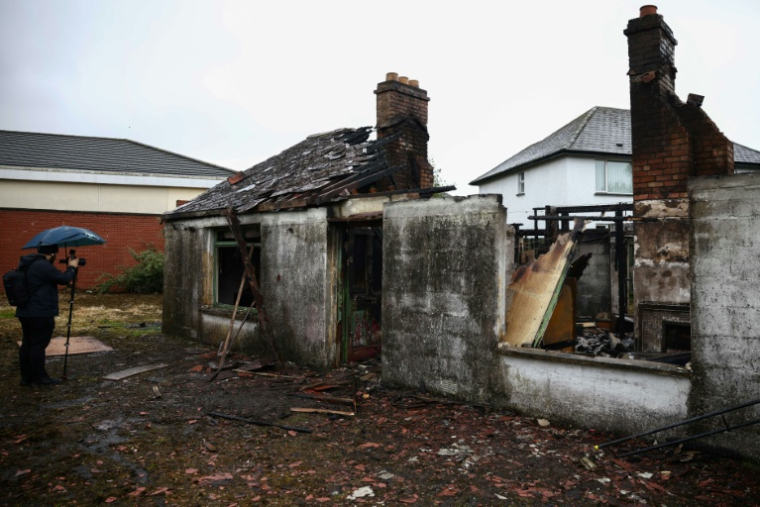 Un bâtiment incendié, le 11 juin 2026, à Glengormley, quartier au nord de Belfast (Irlande du Nord), au lendemain d'une nuit de violences  ( AFP / Henry NICHOLLS )