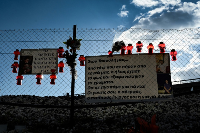 Des hommages sur un grillage longeant la voie de chemin de fer où s'est produit l'accident de train de Tempé en 2023 en Grèce, ici le 24 février 2024 ( AFP / Sakis MITROLIDIS )