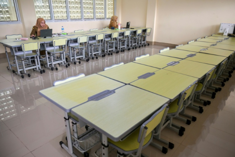 Des enseignantes donnent un cours en ligne depuis une salle de classe vide dans un collège de Pontianak, dans le Kalimantan occidental, le 7 septembre 2026 en Indonésie ( AFP / BAY ISMOYO )