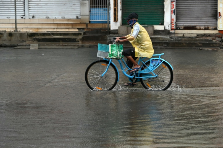 Un homme se déplace à vélo dans une rue inondée à Kakinada, dans l’État de l’Andhra Pradesh, le 28 octobre 2026, après que le cyclone Arnab a touché terre entraînant des vents violents et des pluies torrentielles ( AFP / Noah SEELAM )