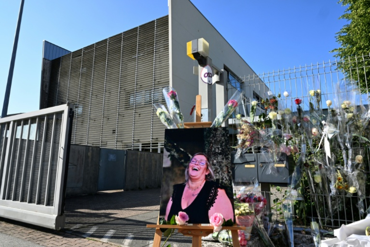 Des fleurs et un portrait en hommage à la surveillante poignardée à mort devant les grilles du collège Françoise-Dolto de Nogent, en Haute-Marne, le 13 juin 2025 ( AFP / FRANCOIS NASCIMBENI )