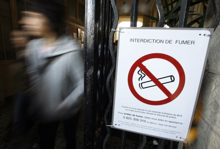 Des écoliers passent devant un panneau d'interdiction de fumer dans leur école à Nice