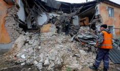 Des ouvriers enlèvent les débris d'un bâtiment résidentiel endommagé par un bombardement à Horlivka