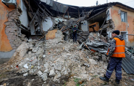 Des ouvriers enlèvent les débris d'un bâtiment résidentiel endommagé par un bombardement à Horlivka