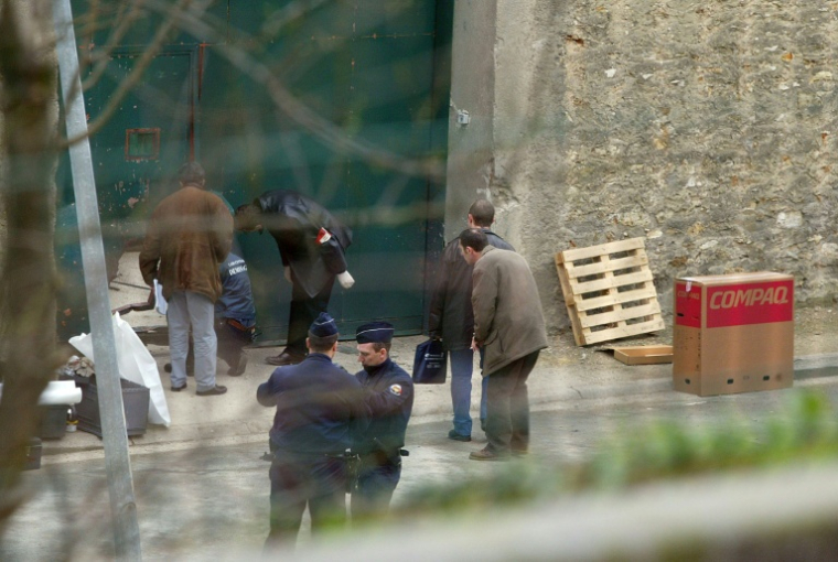 Des enquêteurs relèvent des indices sur la porte arrière de la maison d'arrêt de Fresnes, après l'évasion d'Antonio Ferrara, le 12 mars 2003 ( AFP / MARTIN BUREAU )