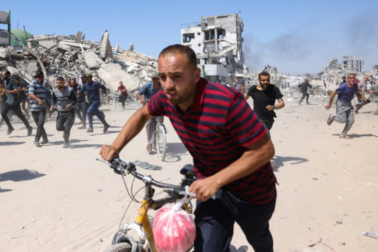 Des Palestiniens courent se mettre à l’abri lors d’une frappe de drone israélien à Jabalia, dans le nord de la bande de Gaza, le 23 mai 2025 ( AFP / Bashar TALEB )