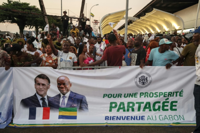 La foule salue le président français Emmanuel Macron à son arrivée dans la capitale gabonaise Libreville, le 23 novembre 2025 ( AFP / Ludovic MARIN )