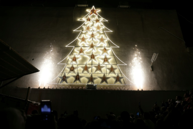 Un arbre de Noël affiche des photos de victimes d'un attentat perpétré dans une église en juin dernier, le 23 décembre 2025 à Damas, en Syrie ( AFP / Bakr ALKASEM )