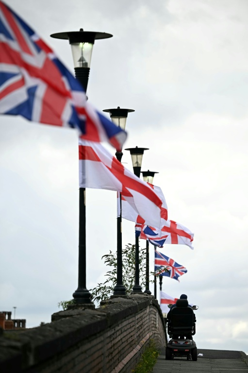 Des drapeaux britanniques et anglais accrochés à des lampadaires à Ellesmere Port, dans le nord-ouest de l'Angleterre, le 2 septembre 2025 ( AFP / Paul ELLIS )