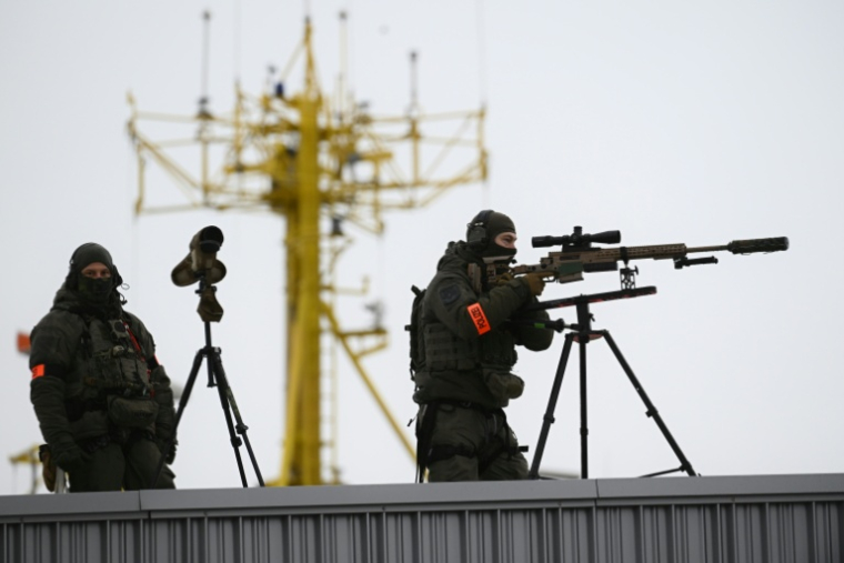 Deux tireurs d'élite de la police allemande sécurisent les environs du Cruise Ship Center Baakenhoeft, l'un des lieux où se tient le Sommet de la mer du Nord, le 26 janvier 2026 à Hambourg ( AFP / Gregor Fischer )