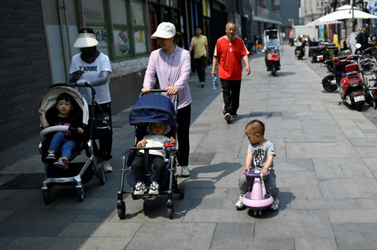 Des femmes avec des poussettes dans une rue de Pékin, le 20 mai 2025 ( AFP / WANG Zhao )