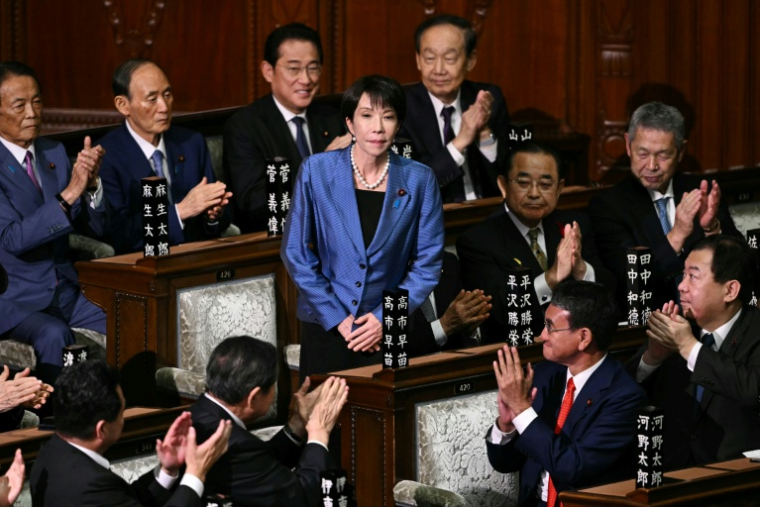 La présidente du Parti libéral démocrate (PLD) Sanae Takaichi (c) est applaudie après avoir été nommée nouvelle Première ministre du Japon lors d'une session extraordinaire de la chambre basse du Parlement à Tokyo, le 21 octobre 2025 ( AFP / Philip FONG )