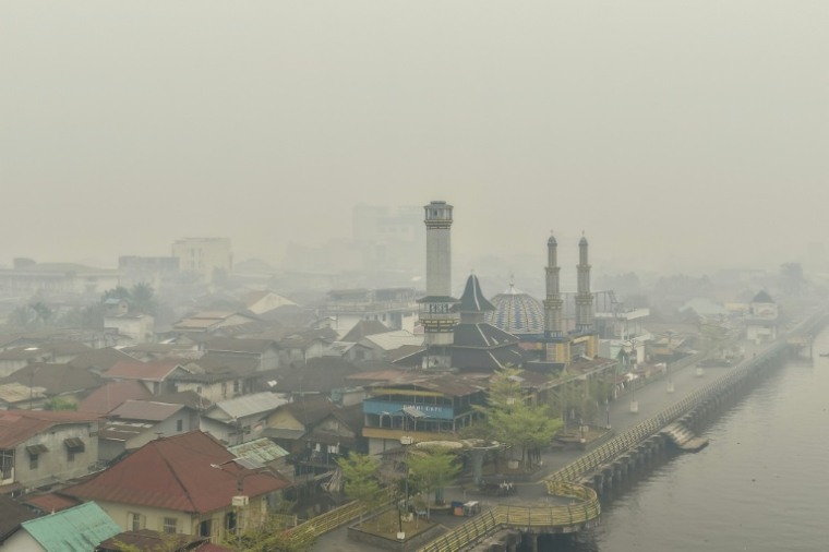 Une épaisse fumée enveloppe des bâtiments au bord du fleuve Kapuas, me 6 septembre 2026 à Pontianak dans le Kalimatan occidental, le 6 septembre 2026 en Indonésie ( AFP / BAY ISMOYO )
