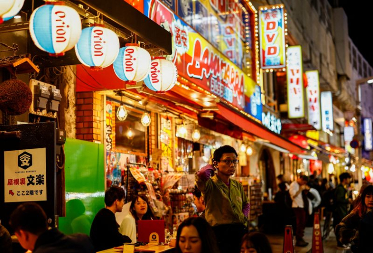 Des personnes boivent et mangent dans des pubs izakaya dans le quartier commerçant d'Ameyoko, à Tokyo
