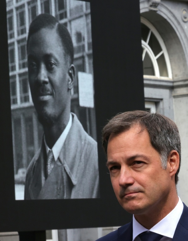 Alexander De Croo, à l'époque Premier ministre belge, devant un portrait géant de Patrice Lumumba, héros de l'indépendance congolaise, arrive au plais d'Egmont pour la restitution d'une dent du dirigeant congolais assassiné, le 20 juin 2022à Bruxelles ( POOL / Olivier Matthys )