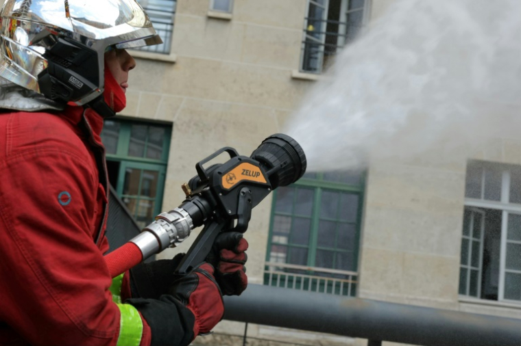 Un pompier de Paris actionne une nouvelle lance à incendie dite "diphasique" lors d'une présentation à la presse à la caserne Champerret à Paris, le 26 juin 2025 ( AFP / Thomas SAMSON )