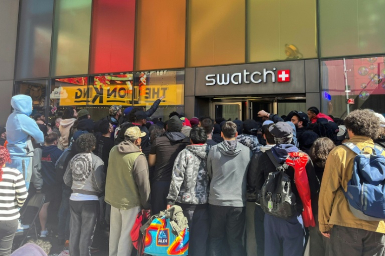 Des personnes attendent pour entrer dans une boutique Swatch à Time Square pour la sortie de la montre Audemars Piguet Swatch "Royal Pop", le 16 mai 2026 à New York ( AFP / Raphaëlle PELTIER )