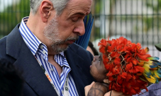 Le président de la COP30, Andre Correa do Lago, tient un bébé indigène de la communauté munduruku lors d'une manifestation à l'entrée de la COP30 à Belem, au Brésil, le 14 novembre 2025 ( AFP / Pablo PORCIUNCULA )