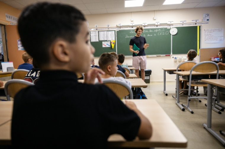 Un professeur accueille les élèves le jour de la rentrée dans l'école primaire Bonnevaine Zenatti à Marseille, le 2 septembre 2024 ( AFP / CLEMENT MAHOUDEAU )