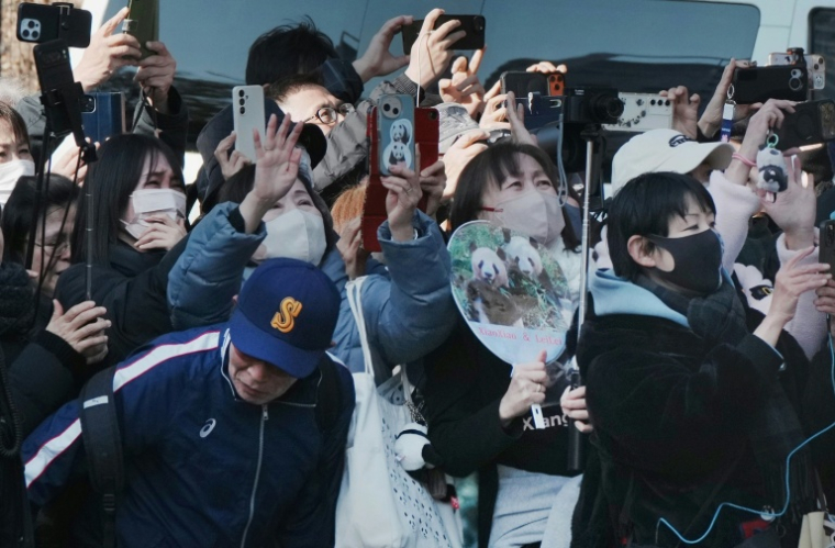 Des admirateurs disent au revoir à un camion dont ils pensent qu'il transporte les pandas jumeaux au moment de leur départ du zoo de Ueno à Tokyo, le 27 janvier 2026 ( AFP / Kazuhiro NOGI )