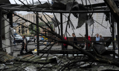 Des piétons passent devant des débris près d'une station de métro après une attaque russe à Kiev, le 21 juillet en Ukraine ( AFP / OLEKSII FILIPPOV )
