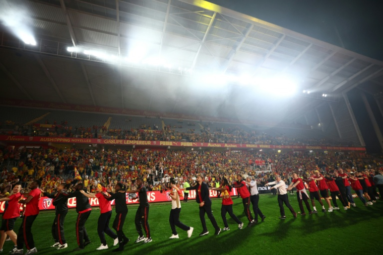 Des membres du RC Lens célèbrent leur victoire à Lens, le 22 mai 2026 ( AFP / FRANCK FIFE )