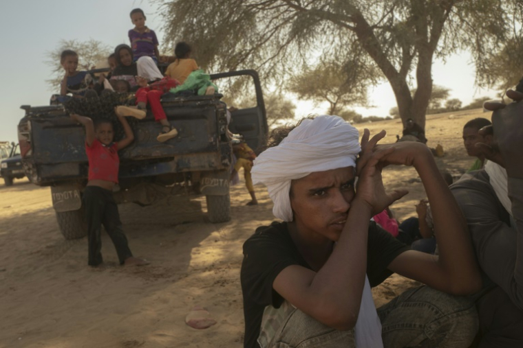 Une famille de réfugiés maliens, qui a fui avec ses proches la ville de Leré, se repose après avoir traversé la frontière mauritanienne au poste frontière de Douankara, à Fassale, le 4 novembre 2025. ( AFP / MICHELE CATTANI )