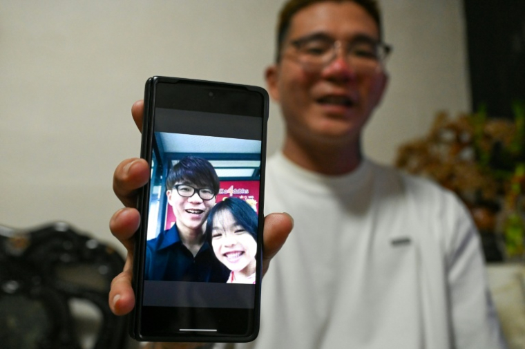 Delfard Tay montre une photo de sa fille Shermaine, avant son décès, le 18 septembre 2025 à Singapour ( AFP / Roslan RAHMAN )