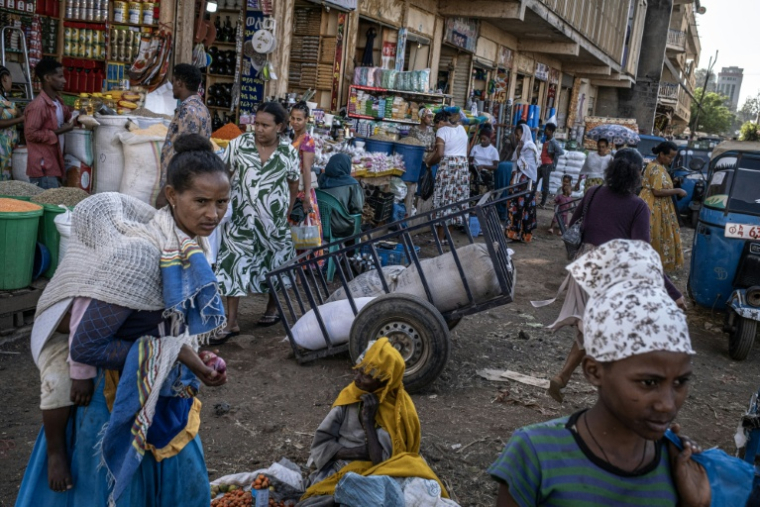 Des acheteurs et des vendeurs transportent des marchandises à l'intérieur du marché Kebele 4 à Bahir Dar, le 9 décembre 2025 ( AFP / Marco Simoncelli )