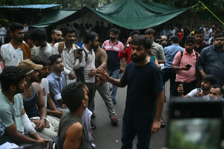 Abhijeet Dipke, fondateur du "parti des cafards", s'entretient avec des manifestants blessés lors d'une mobilisation réclamant la démission du ministre de l'Education, Dharmendra Pradhan, en raison de fraudes présumées aux examens universitaires, le 21 juillet 2026 à New Delhi, en Inde ( AFP / Arun SANKAR )