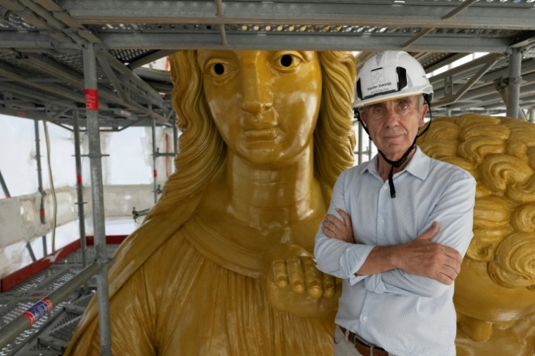 French architecte Xavier David, in charge of the restoration project of the Notre-Dame de la Garde, poses next to the statue of the Virgin Mary, in Marseille on September 3, 2025. ( AFP / Miguel MEDINA )