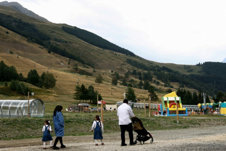 Une famille juive orthodoxe dans la station des Deux Alpes, en Isère, le 19 août 2026 ( AFP / Alex MARTIN )