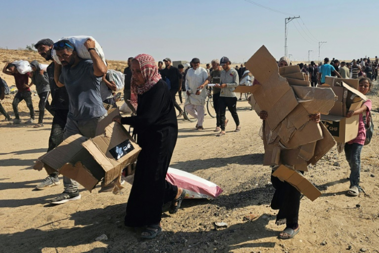 Des Palestiniens déplacés marchent le long d'une route pour recevoir des colis d'aide humanitaire d'un centre d'aide soutenu par les États-Unis à Rafah, dans le sud de la bande de Gaza, le 5 juin 2025 ( AFP / - )