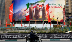 Un motocycliste passe devant un panneau représentant les trois guides suprêmes iraniens, le 10 mars 2026 à Téhéran ( AFP / - )