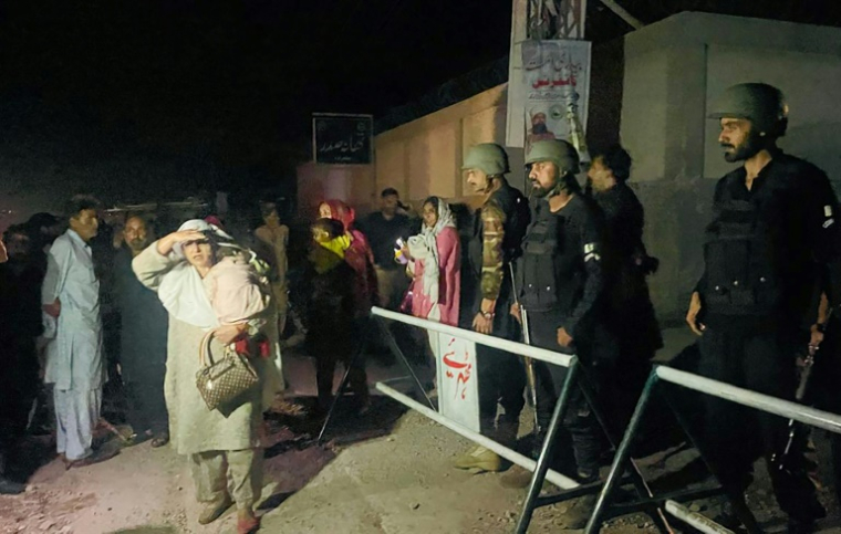 Les forces de sécurité pakistanaises bloquent une rue alors que des habitants fuient leurs maisons après une frappe à Muzaffarabad, au Cachemire pakistanais, le 7 mai 2025 ( AFP / Sajjad QAYYUM )