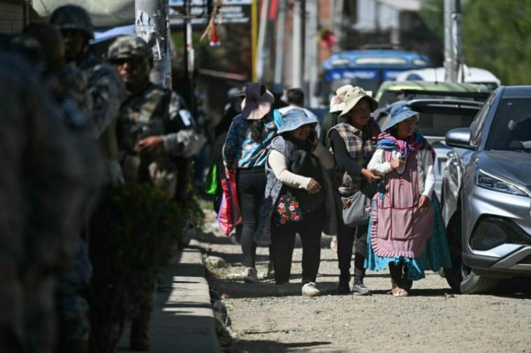Des personnes empruntent une route après sa réouverture, auparavant bloquée par des manifestants exigeant la démission du président Rodrigo Paz,  le 5 juin 2026 à Carreras, dans le département de La Paz, en Bolivie ( AFP / MARVIN RECINOS )