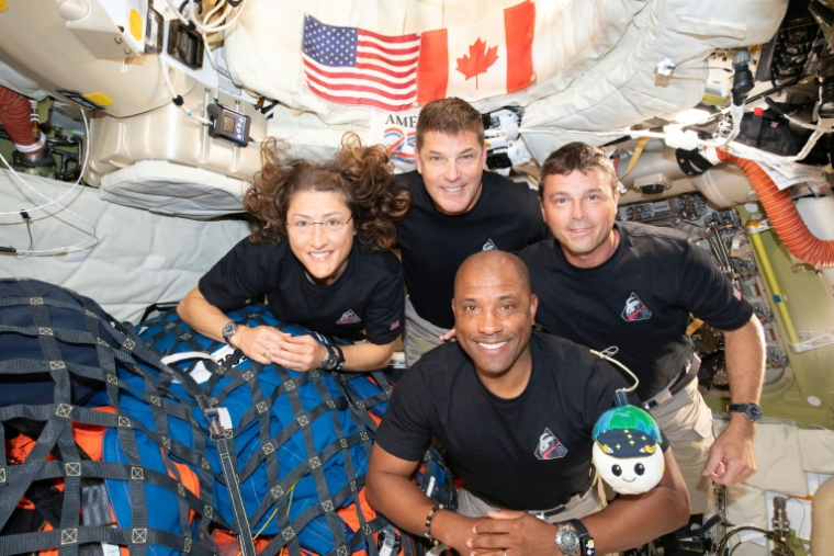 Photo diffusée le 8 avril 2026 par la Nasa montrant les membres d'équipage d'Artémis II, Christina Koch, Jeremy Hansen (haut), Reid Wiseman (d) et Victor Glover (bas), à bord du vaisseau spatial Orion, le 7 avril 2026 ( NASA / Handout )