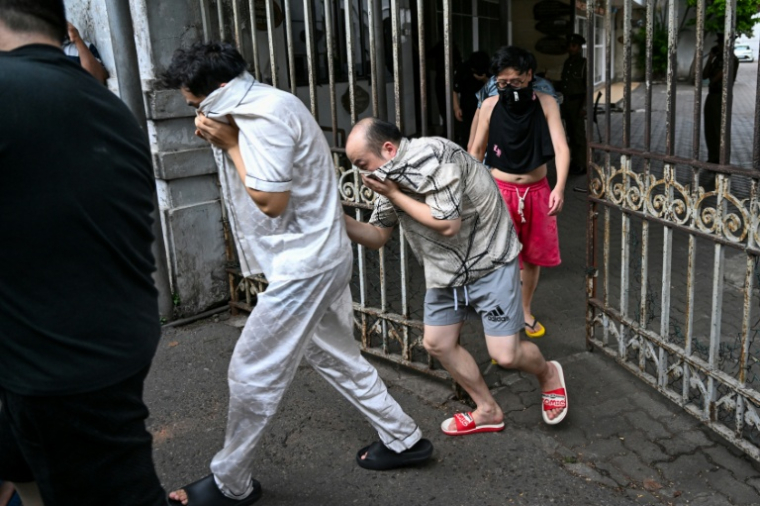 Des ressortissants chinois suspectés d'appartenir à un réseau de cybercriminalité sont escortés vers une prison sri-lankaise après leur arrestation à Colombo, le 9 mai 2026 ( AFP / Ishara S. KODIKARA )