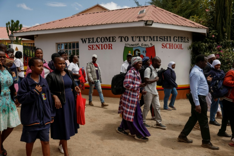 Des proches attendent devant l'école pour filles Utumishi où est survenu un incendie meurtrier, le 28 mai 2026 à Gilgil, au Kenya ( AFP / SIMON MAINA )