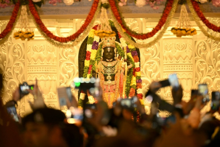 Des fidèles hindous rassemblés devant une statue du dieu Ram au temple d'Ayodhya, dans le nord de l'Inde, le 22 janvier 2024  ( AFP / Money SHARMA )