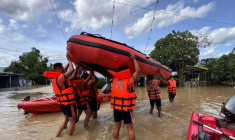 Des secouristes transportent des bateaux pneumatiques pour évacuer des habitants près de Tuguegarao, au nord de Manille, alors que les eaux de crue continuent d'inonder les maisons en raison des fortes pluies provoquées par le super typhon Fung-wong, le 11 novembre 2025 aux Philippines ( AFP / John Dimain )