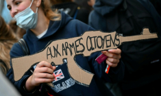 Une élève tient une pancarte en forme de fusil "Aux armes, citoyens" devant le lycée Turgot le 5 octobre 2026 à Paris ( AFP / LOU BENOIST )