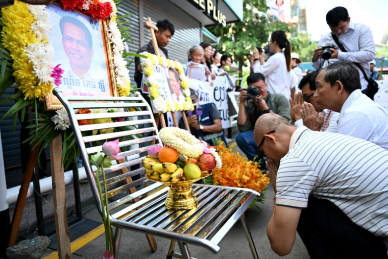 Des personnes réunies devant des portraits de Kem Ley, critique du gouvernement cambodgien abattu il y a dix ans, à Phnom Penh le 10 juillet 2026 ( AFP / TANG CHHIN Sothy )