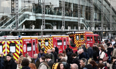 Des pompiers et passagers devant la Gare Montparnasse, partiellement évacuée après le tir d'un policier contre un hommme armé d'un couteau le 14 novembre 2025 à Paris ( AFP / Thibaud MORITZ )