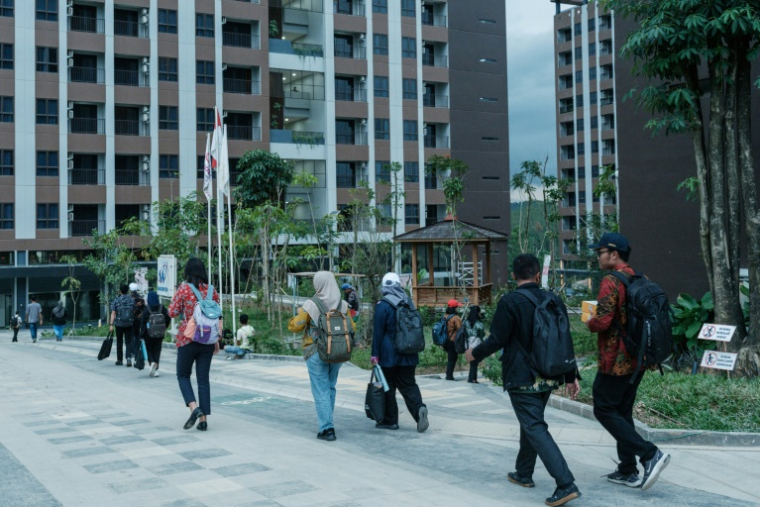 Des fonctionnaires se dirigent vers leurs appartements après leur arrivée en navette à Ibu Kota Nusantara (IKN), la nouvelle capitale prévue de l'Indonésie, le 15 août 2025 ( AFP / YASUYOSHI CHIBA )