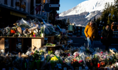 Des fleurs déposées près du bar Le Constellation à Crans-Montana, en Suisse, en hommage aux victimes de l'incendie, le 4 janvier 2026  ( AFP / MAXIME SCHMID )