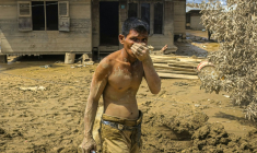 Cette photo prise le 5 décembre 2025 montre un homme couvert de boue devant une maison dans une zone inondée à Aceh Tamiang, dans la province d'Aceh, sur l'île de Sumatra, en Indonésie ( AFP / AMANDA JUFRIAN )