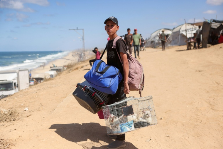 Un jeune Palestinien transporte ses affaires au nord-ouest du camp de Nousseirat, dans la bande de Gaza, le 1er octobre 2025 ( AFP / Bashar TALEB )